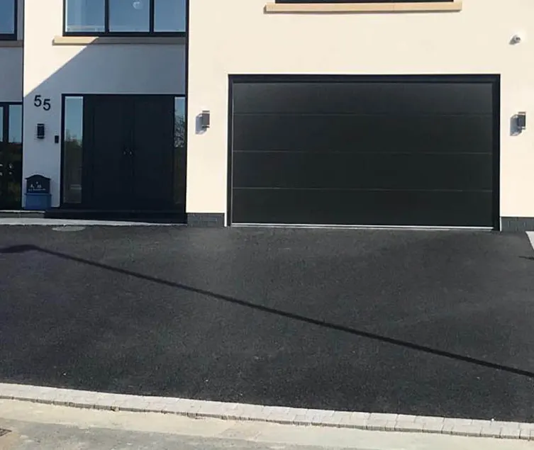 Decorative resin driveway leading to a family home