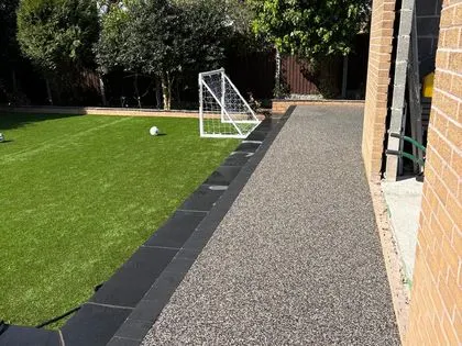 Artificial lawn beside a resin bound garden terrace and path