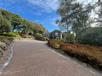 Sweeping resin bound driveway leading to a country stone house