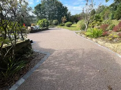 Large resin bound driveway surrounded by mature gardens