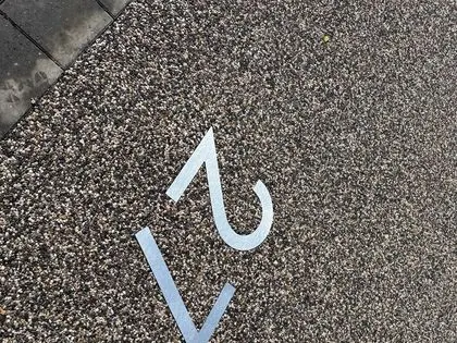 Close-up of a resin bound surface with a decorative metal house number